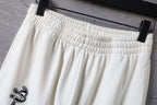 White pants with elastic waistband and gathered pleats at the top