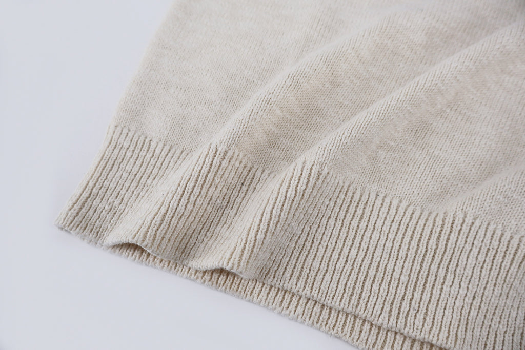 Light beige knit sweater ribbed hem detail at bottom