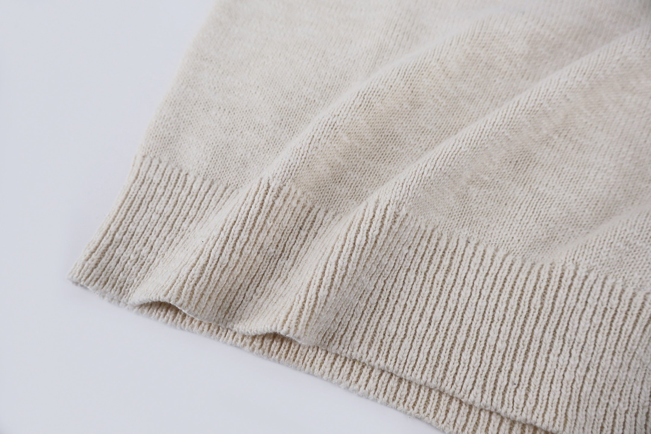 Light beige knit sweater ribbed hem detail at bottom