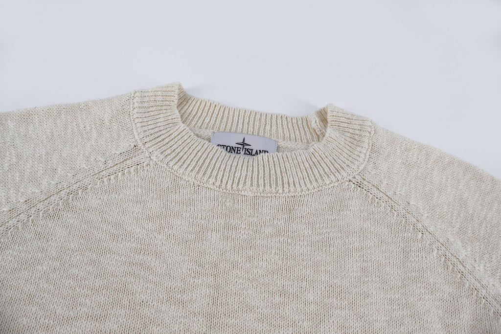Light beige knit sweater neckline close-up, ribbed crew neck and seams