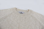 Light beige knit sweater neckline close-up, ribbed crew neck and seams