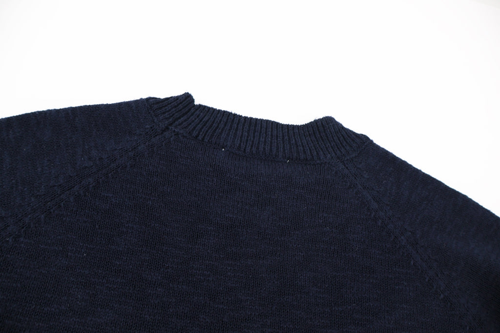 Dark navy knit sweater shoulder and upper back with ribbed crew collar