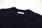 Dark navy crewneck sweater with ribbed collar and small interior brand label