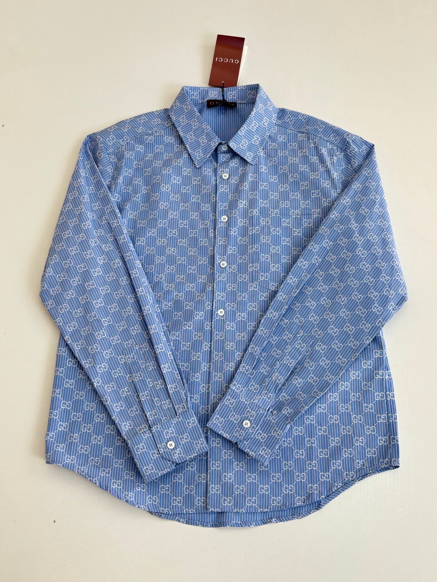 Blue Gucci long-sleeve button-up with allover logo pattern and front button placket