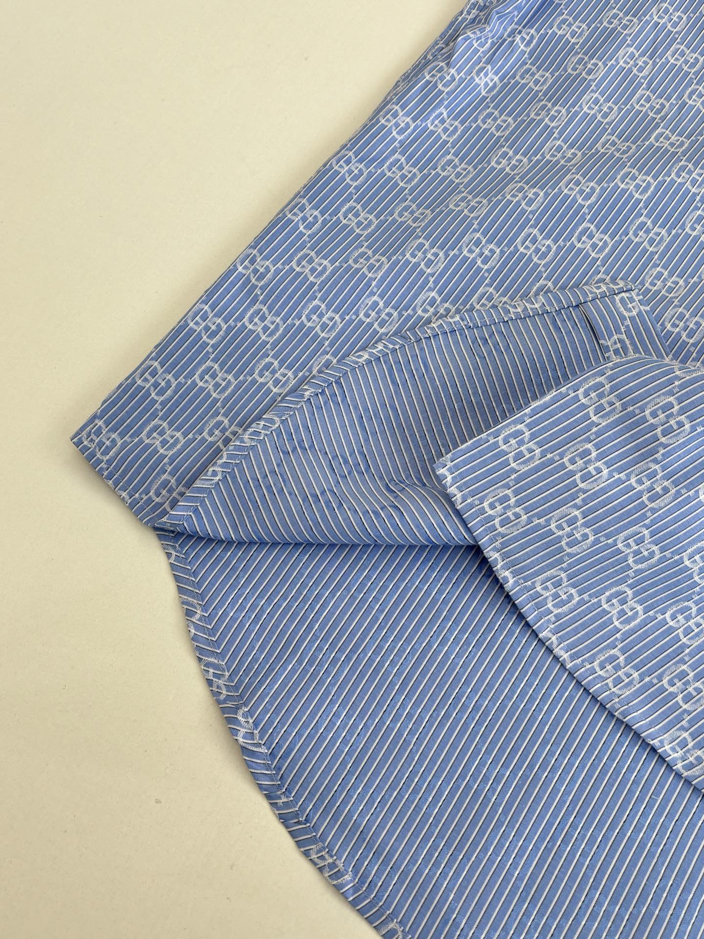 Blue Gucci long-sleeve shirt with allover logo pattern, draped side