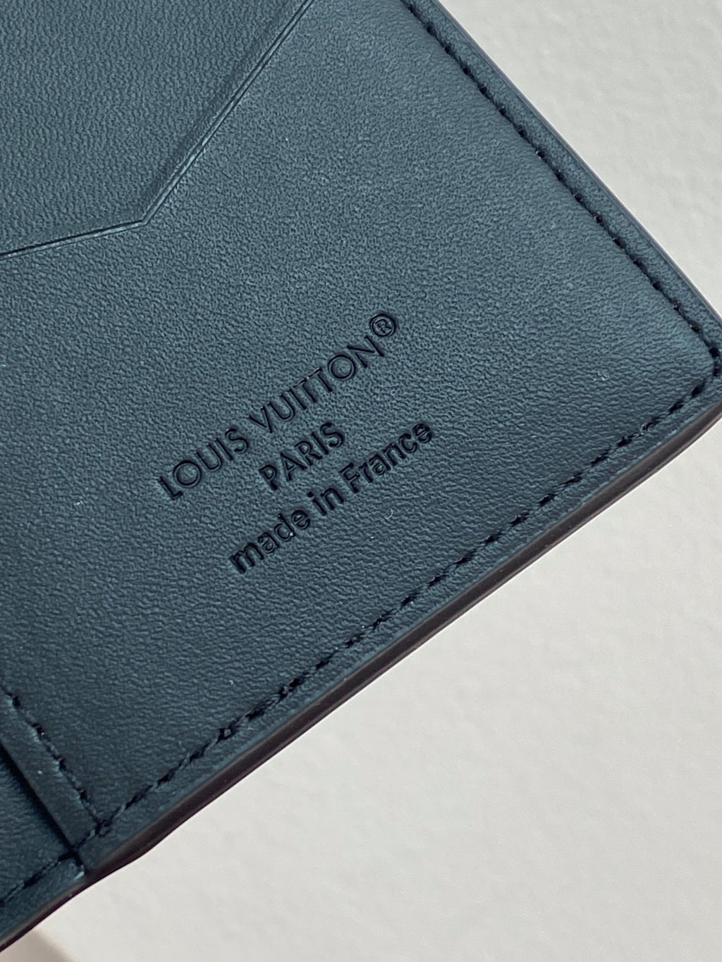 Small leather card holder wallet, close-up of Louis Vuitton logo and made in France