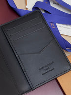 Small leather card holder wallet, close-up of card slots and stitching, dark blue-gray
