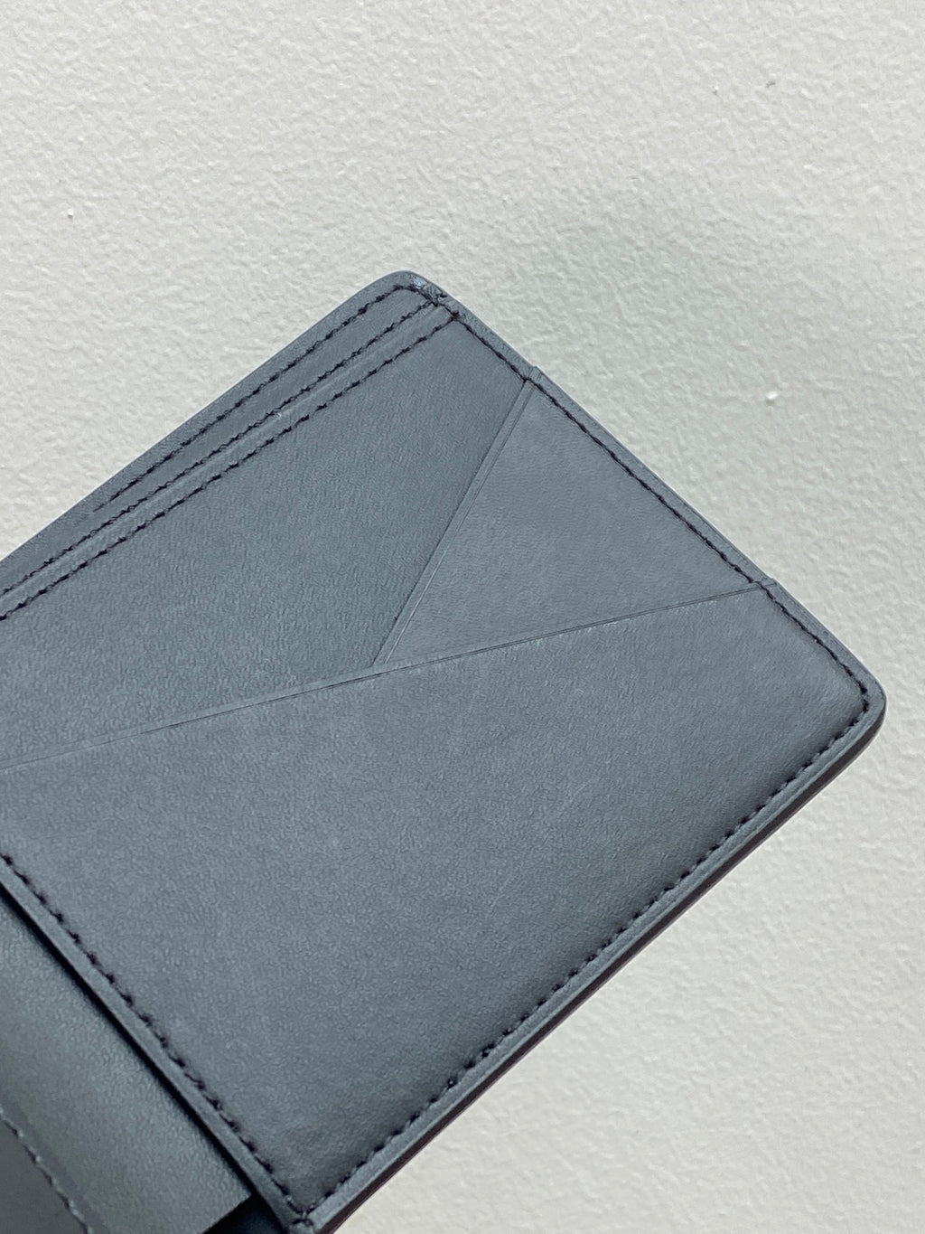 Blue leather wallet card holder with top edge stitching and folded corner
