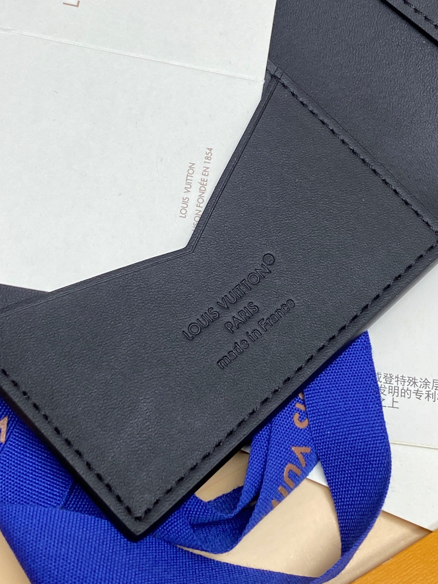 Black textured leather small bag corner with LV logo and stitched tab