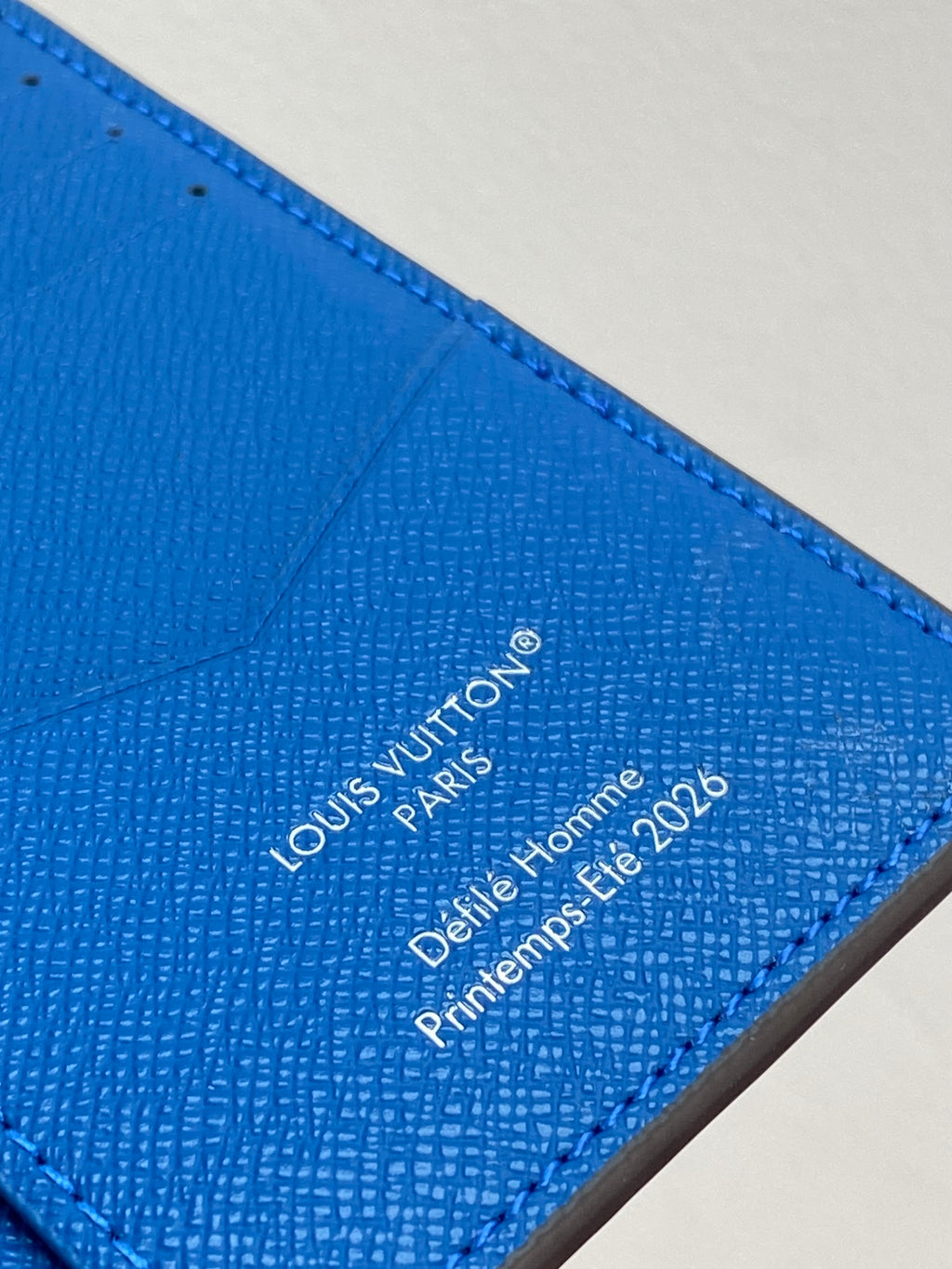 Small bag card holder close-up of Louis Vuitton Paris text on blue leather