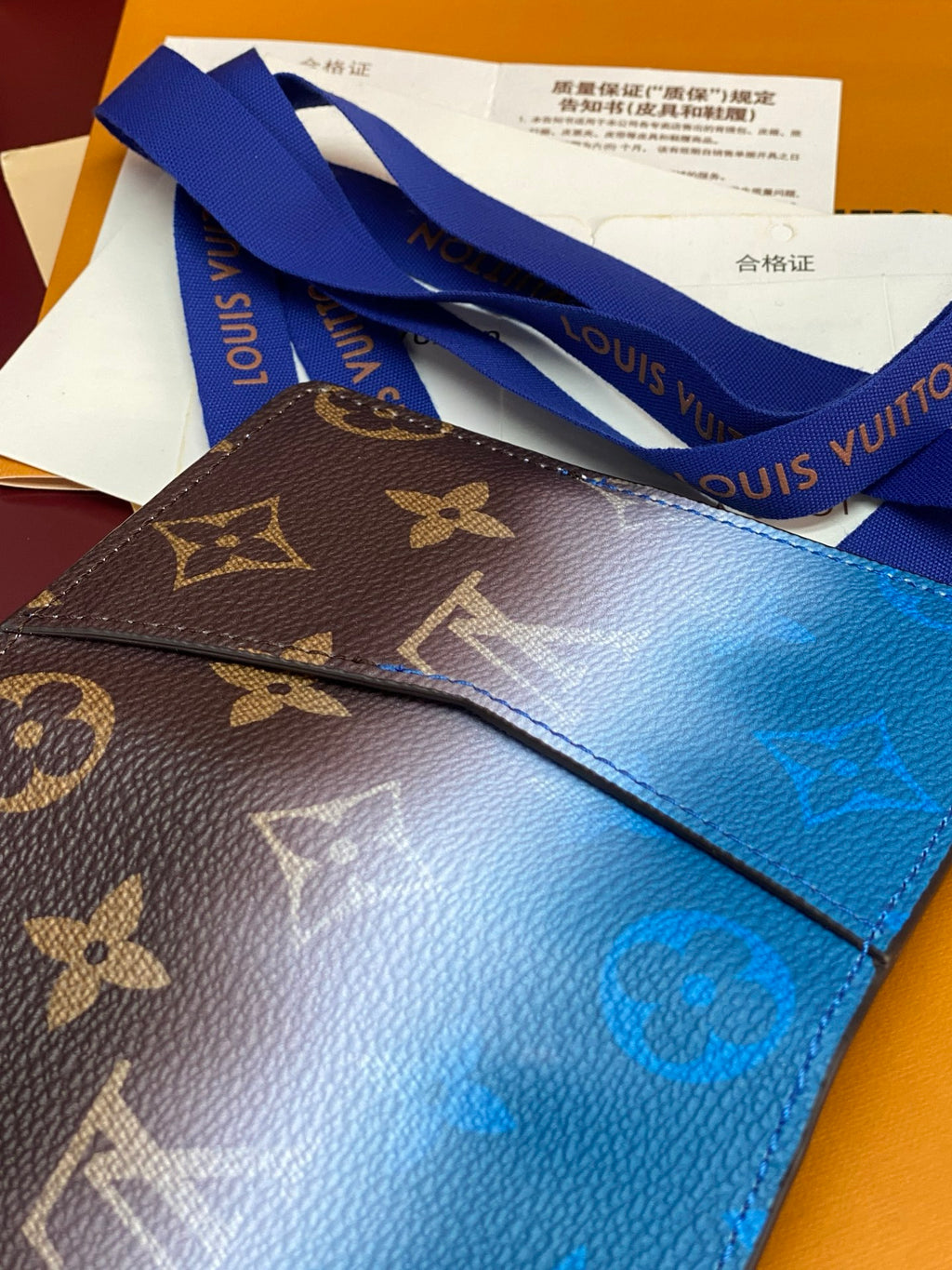 Small bag card holder with Louis Vuitton monogram and blue leather panel, side view