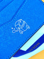 Blue small bag close-up of embossed logo on textured flap