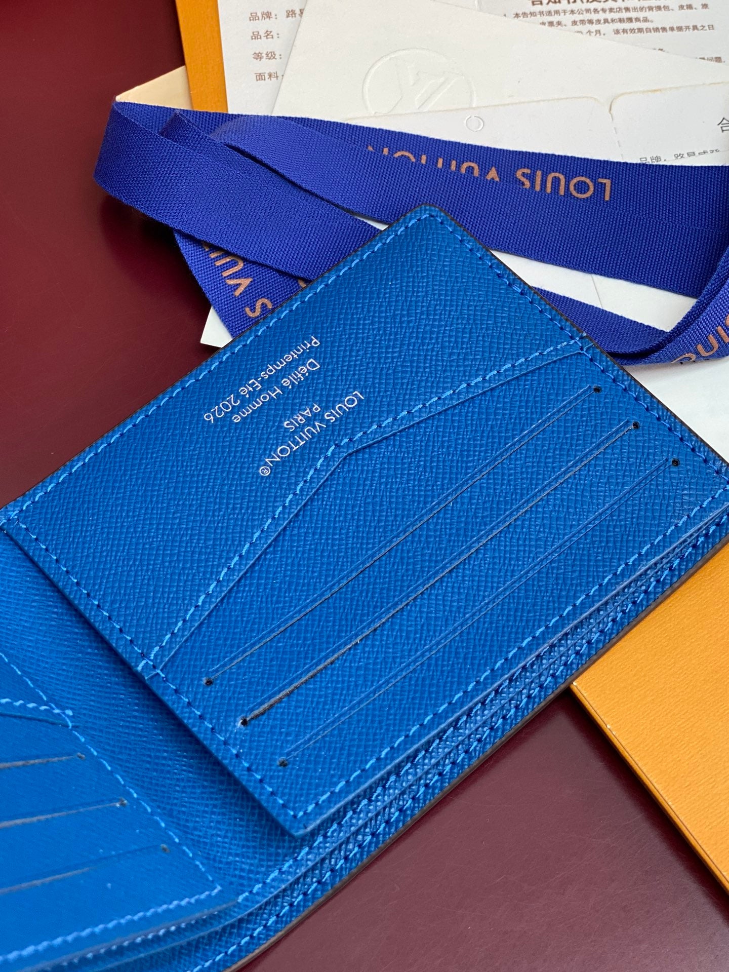 Blue small bag card case with stitched lines and interior slot panel