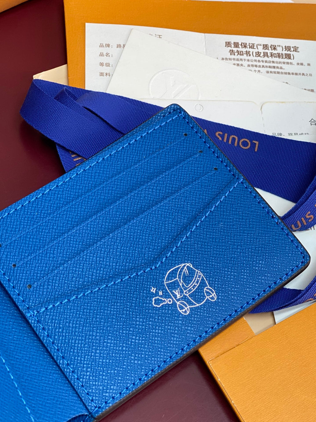 Blue small bag close-up of embossed logo on flap front and card slots