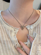 Gold-tone bow pendant necklace worn over knit top neckline