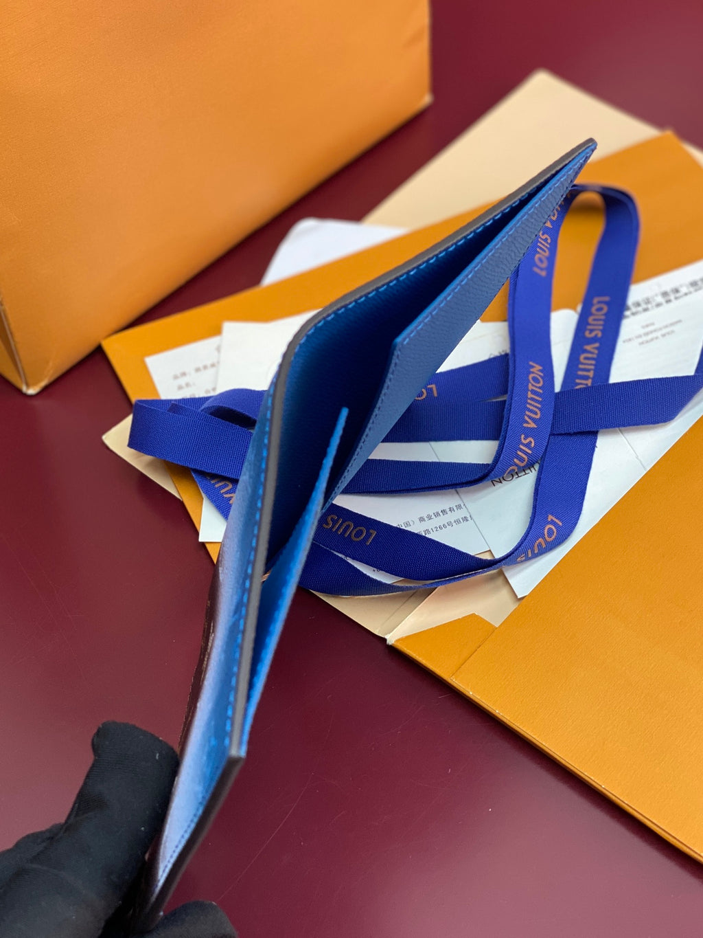 Louis Vuitton small bag with blue leather exterior and attached wrist strap