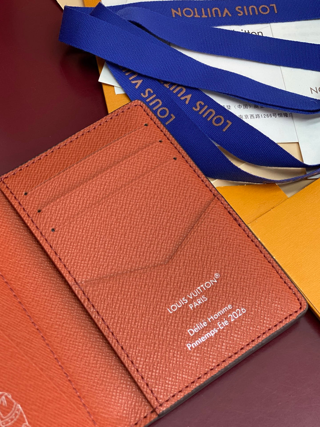 Louis Vuitton small wallet close-up of red interior card slot and stitched logo