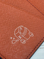 Louis Vuitton small wallet close-up of cartoon emblem on red leather surface