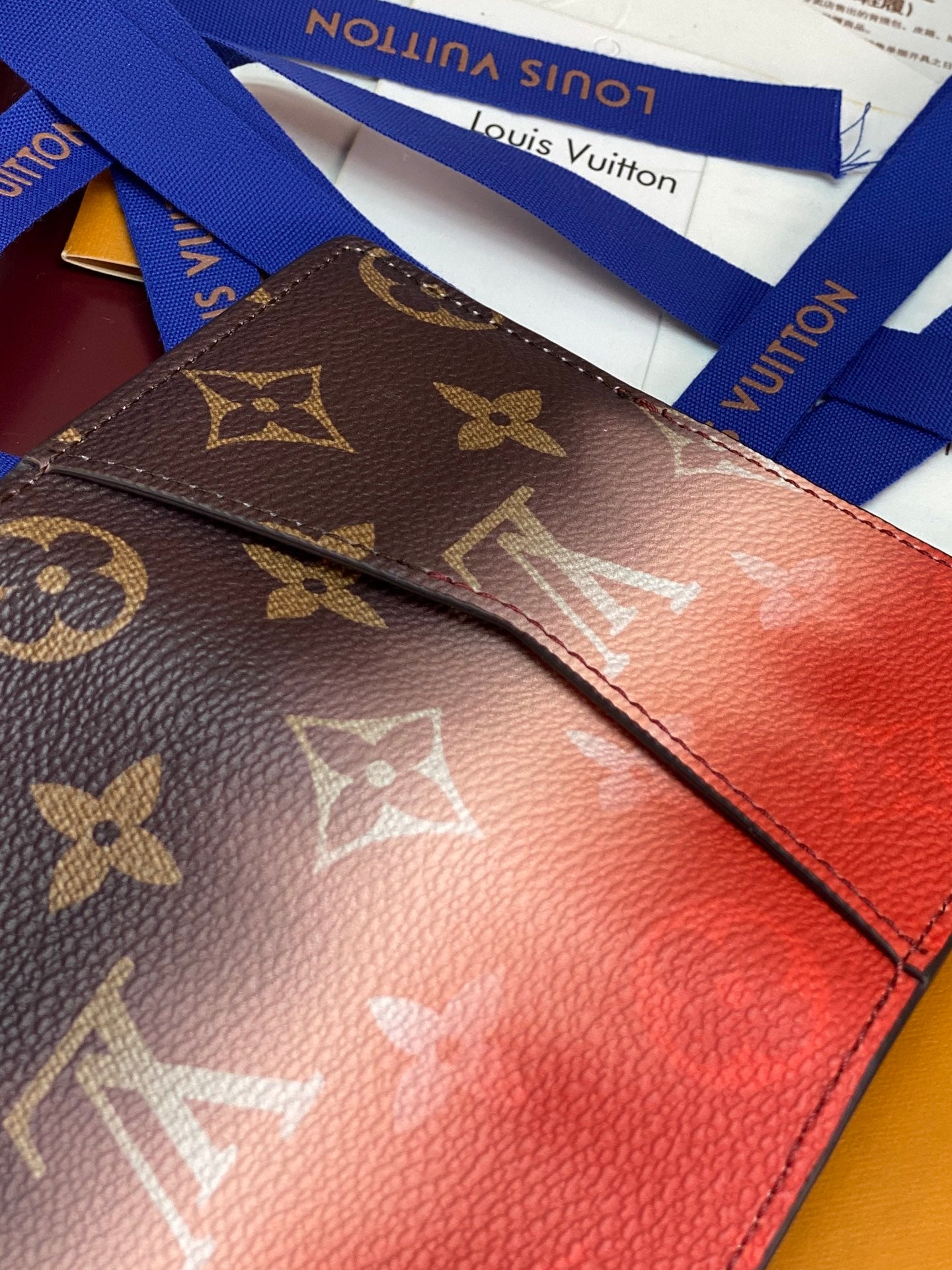 Louis Vuitton small wallet corner close-up with monogram print and red leather edge