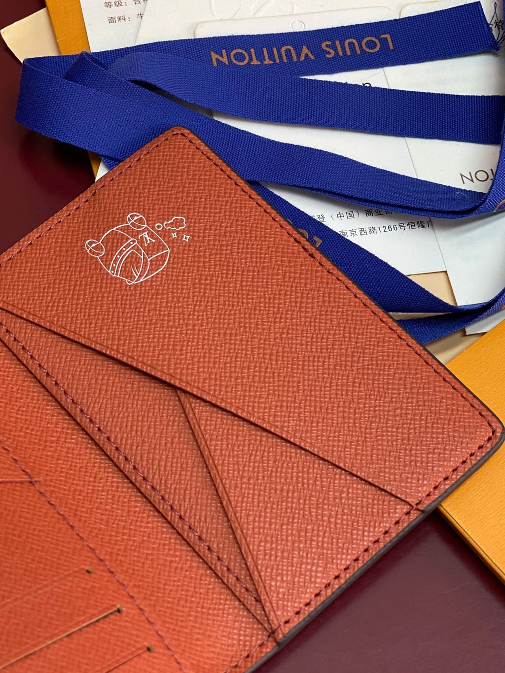 Louis Vuitton small wallet back close-up with embossed emblem and stitched fold