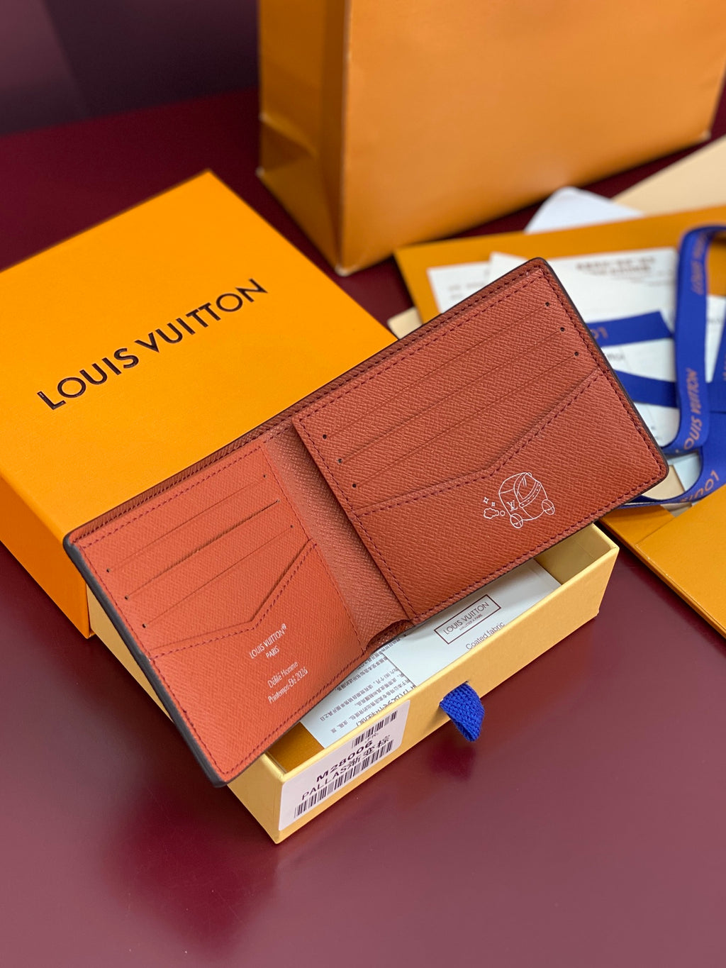Small bi-fold card wallet open, textured tan leather interior