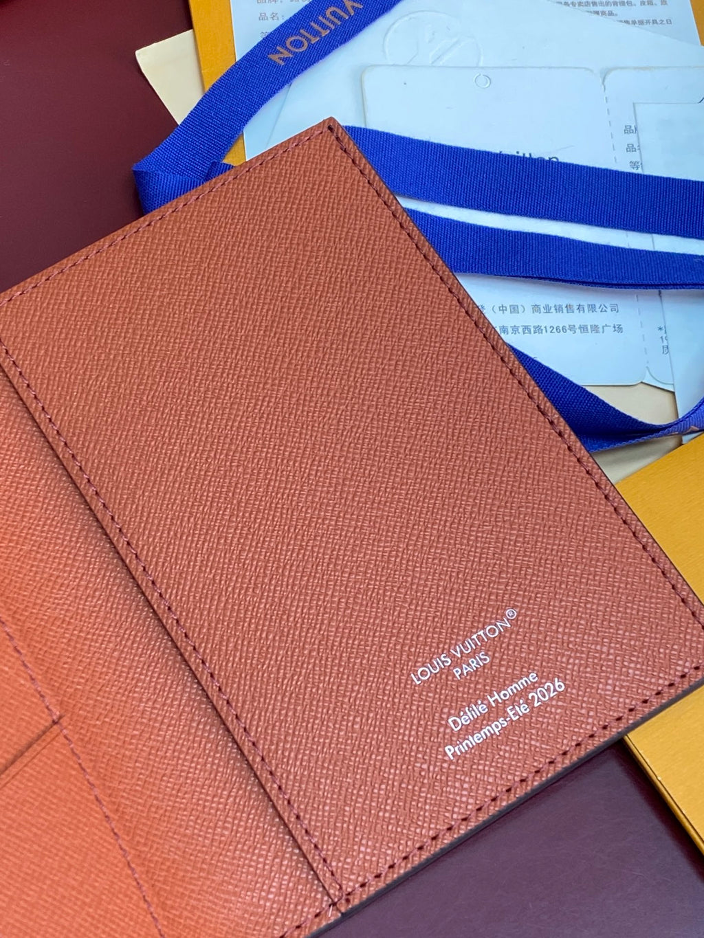 Brown leather Louis Vuitton small bag wallet with embossed text and stitched edge