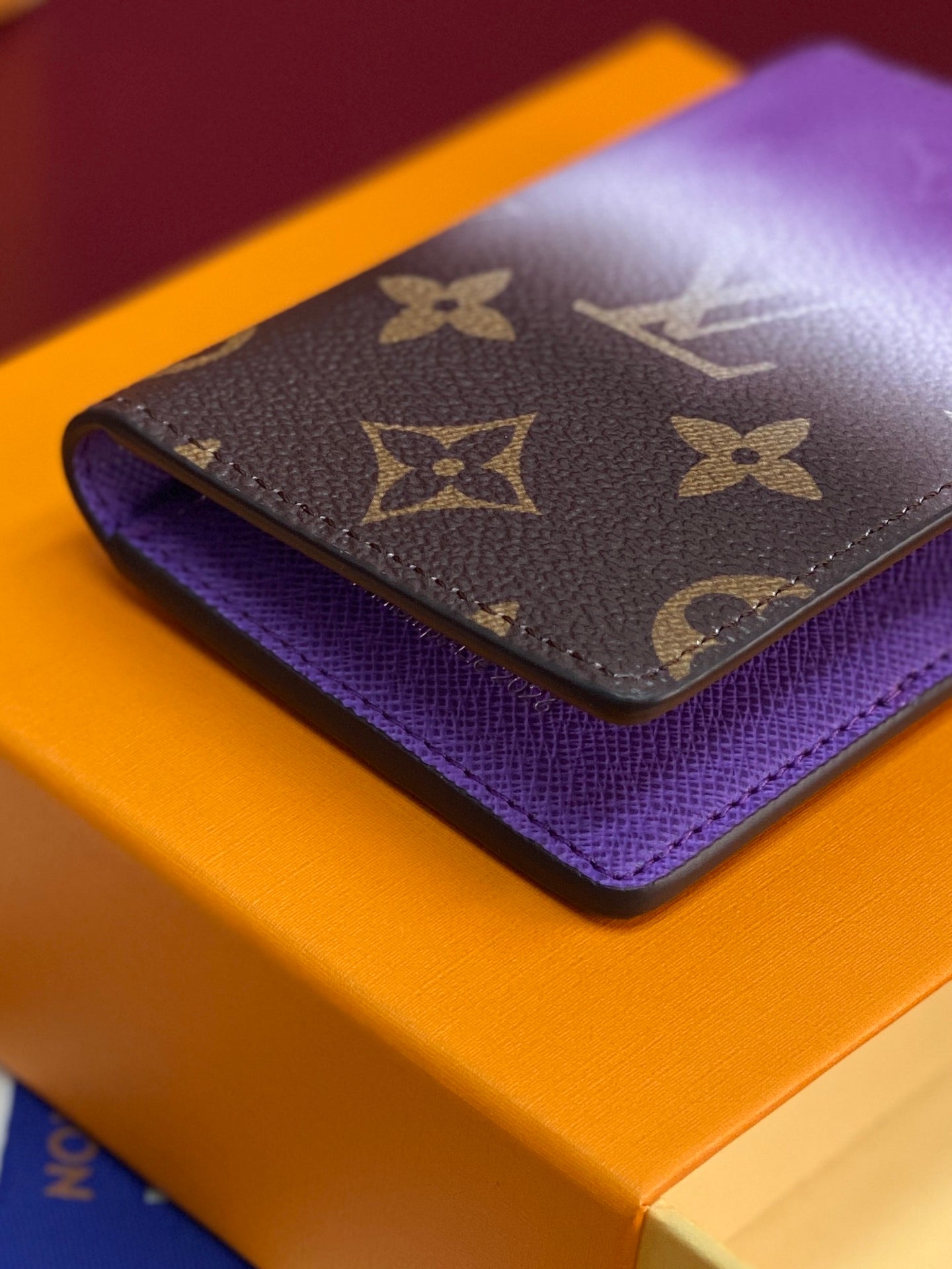 Small bag card holder on purple interior with brown monogram and textured leather finish