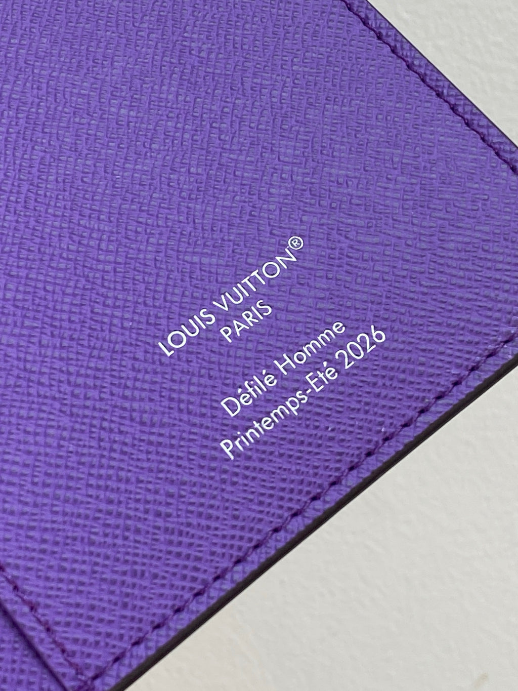 Purple small bag with Louis Vuitton Paris 'Delie Homme 2026' text