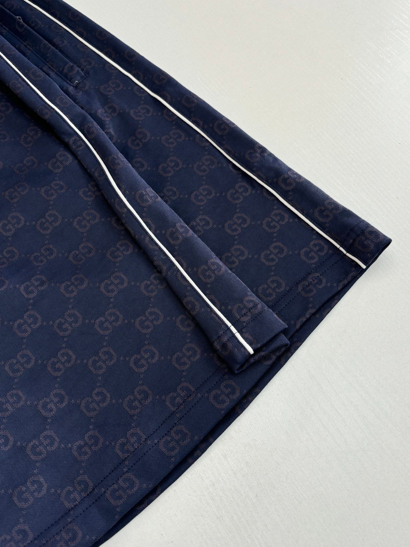 Navy patterned shorts with contrast side stripe and straight cut legs, close-up