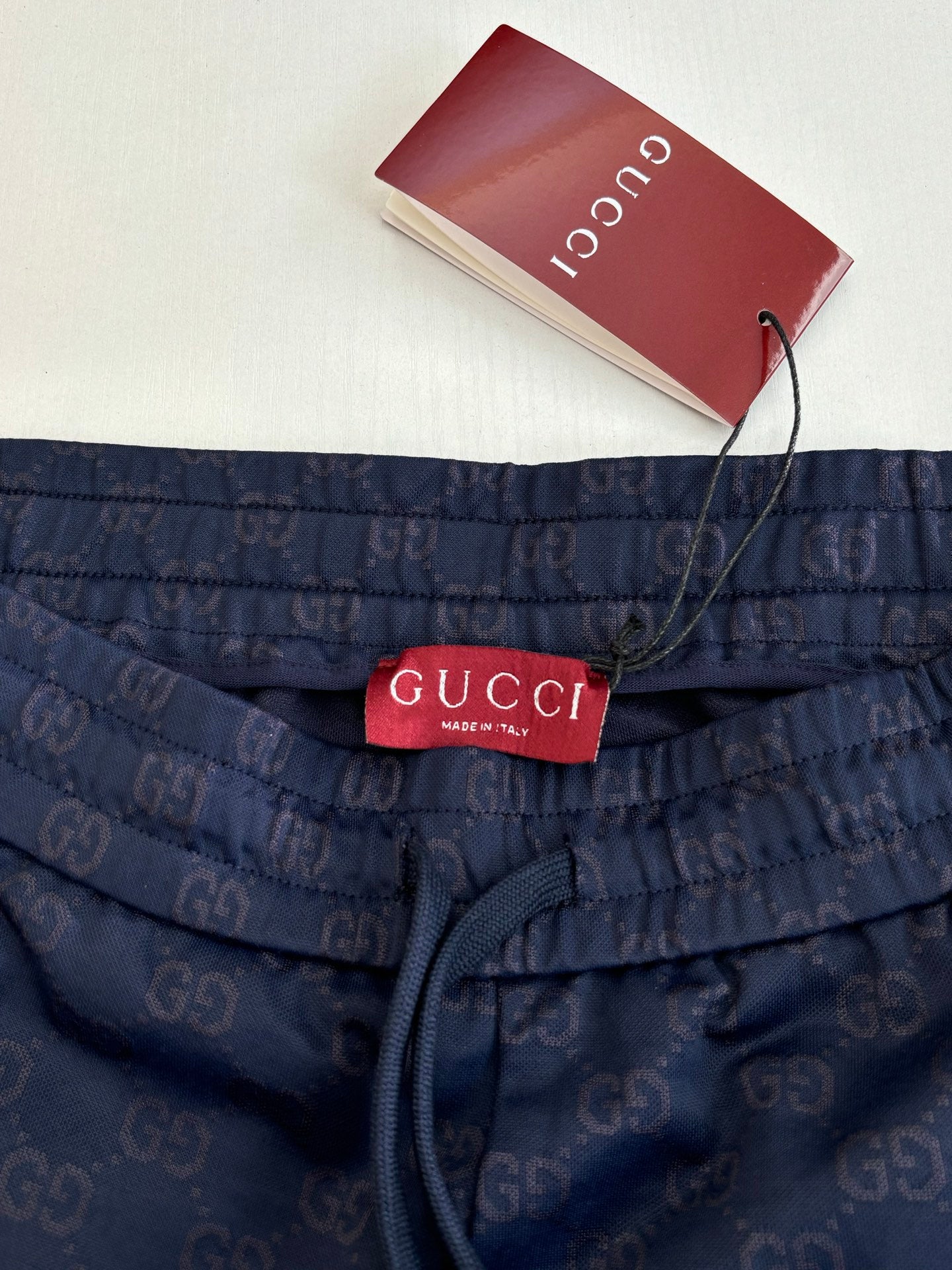 Navy shorts with elastic waist, drawstring, and Gucci label at center front