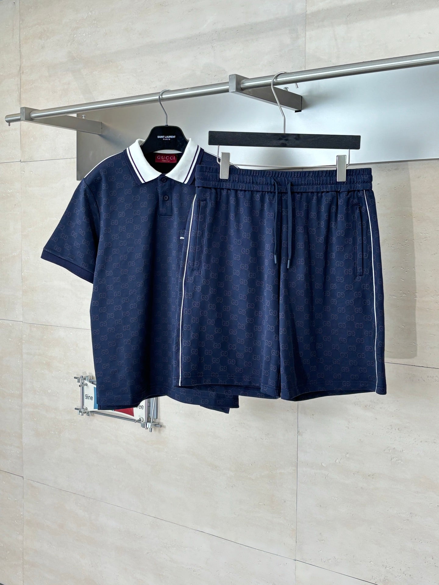 Navy patterned drawstring shorts with elastic waistband, hanging with matching top