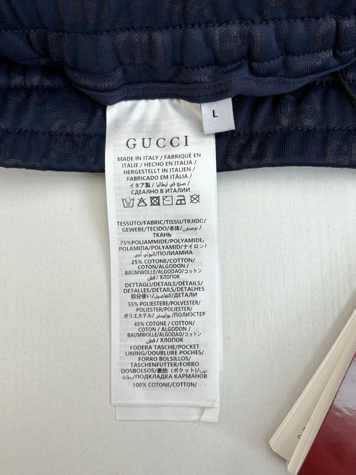 Navy shorts care label inside waistband with size tag, close-up