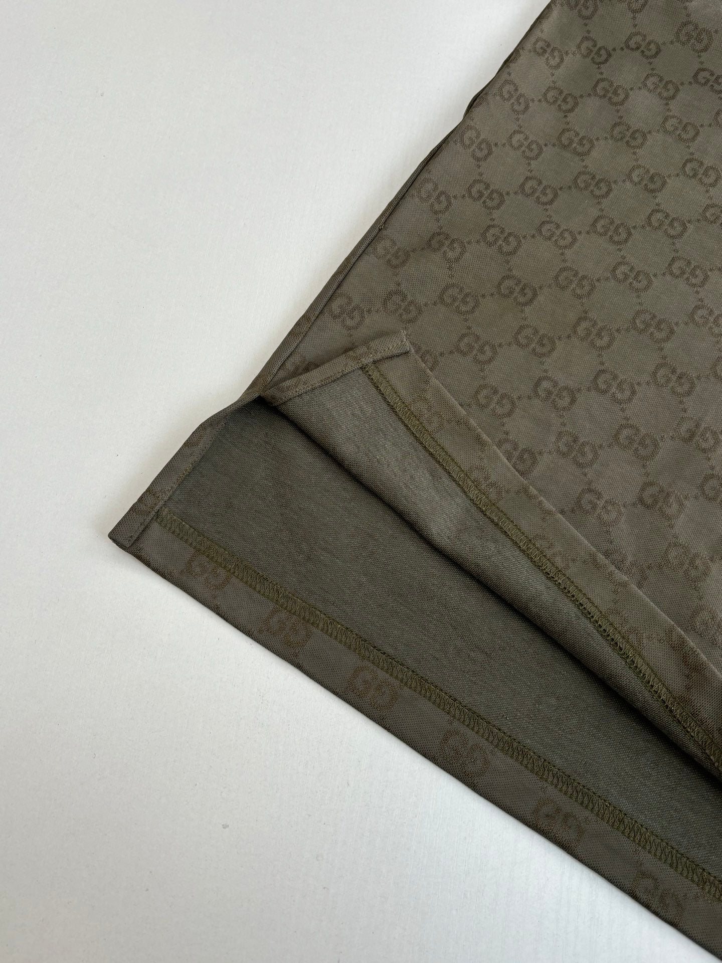 Gucci monogram shorts with dark olive fabric and side seam stripe, flat lay