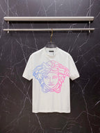 White T-shirt with blue and pink Medusa-style graphic on the chest, crew neck.