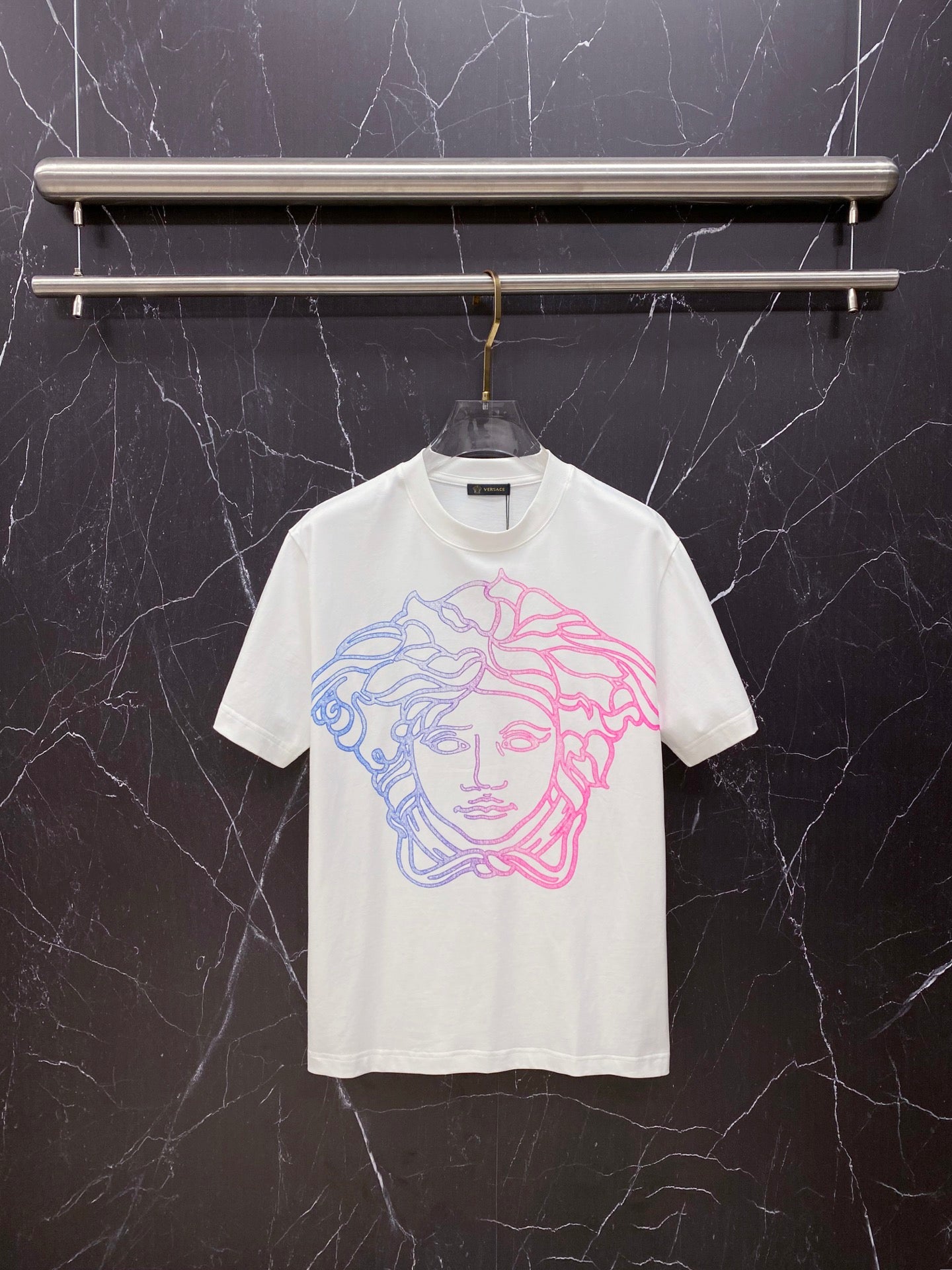 White T-shirt with blue and pink Medusa-style graphic on the chest, crew neck.