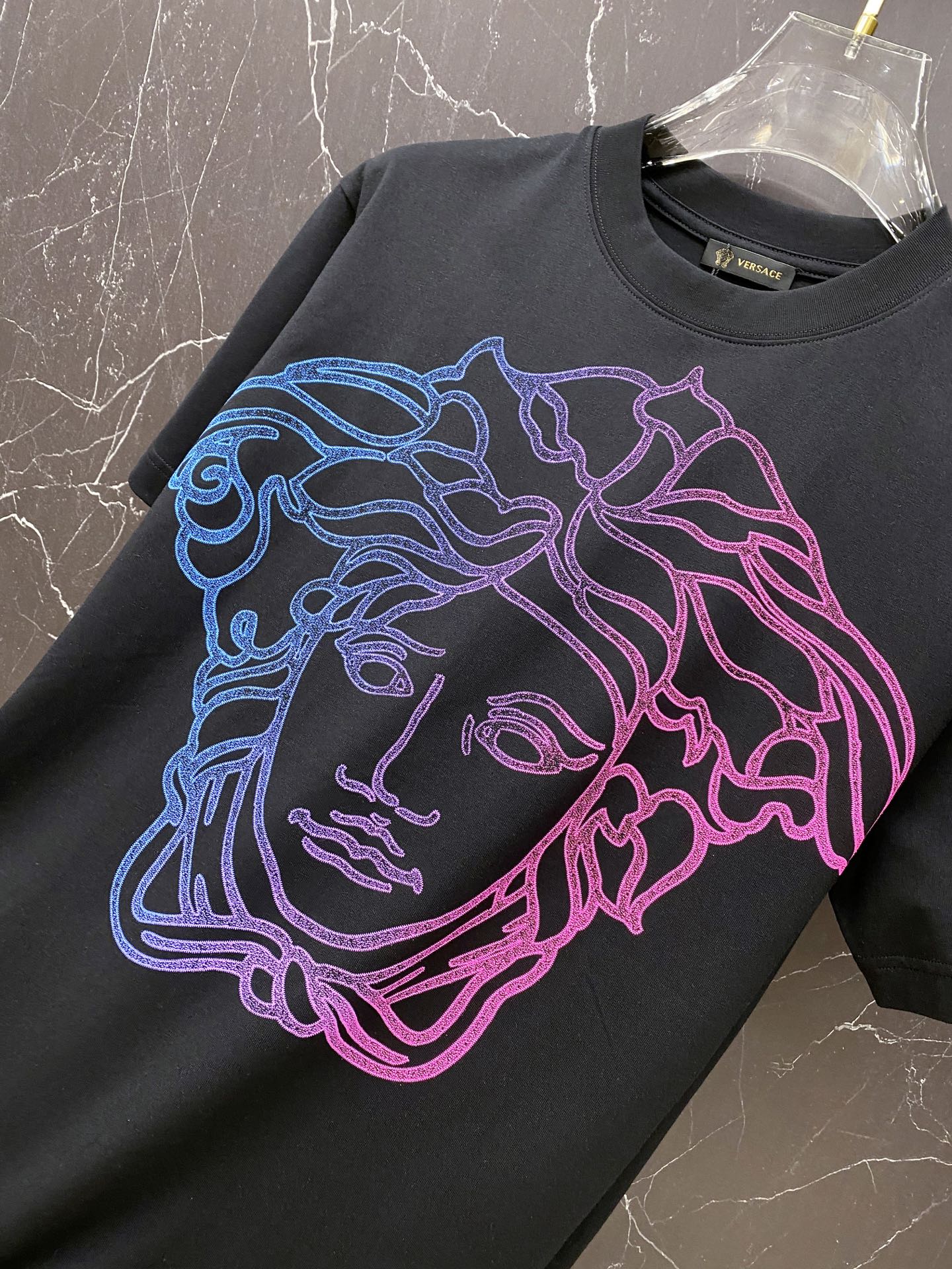 Black graphic T-shirt with large neon blue and pink Medusa face print