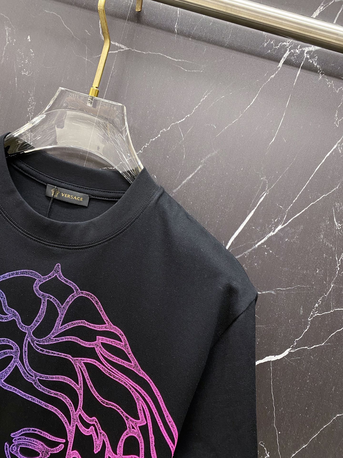Black crewneck T-shirt with neon blue and pink Medusa graphic