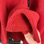 Red knit sweater sleeve and cuff with high collar zipper edge detail
