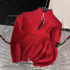 Red knit zip-up sweater with high collar and front zipper, draped on metal rack