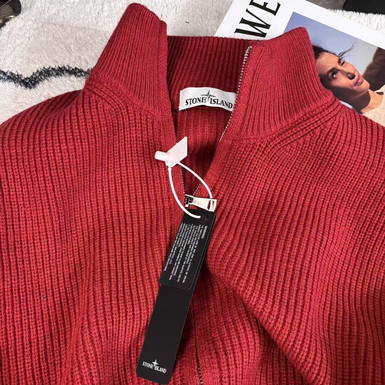 Red knit sweater collar close-up with front zipper and Stone Island logo tag