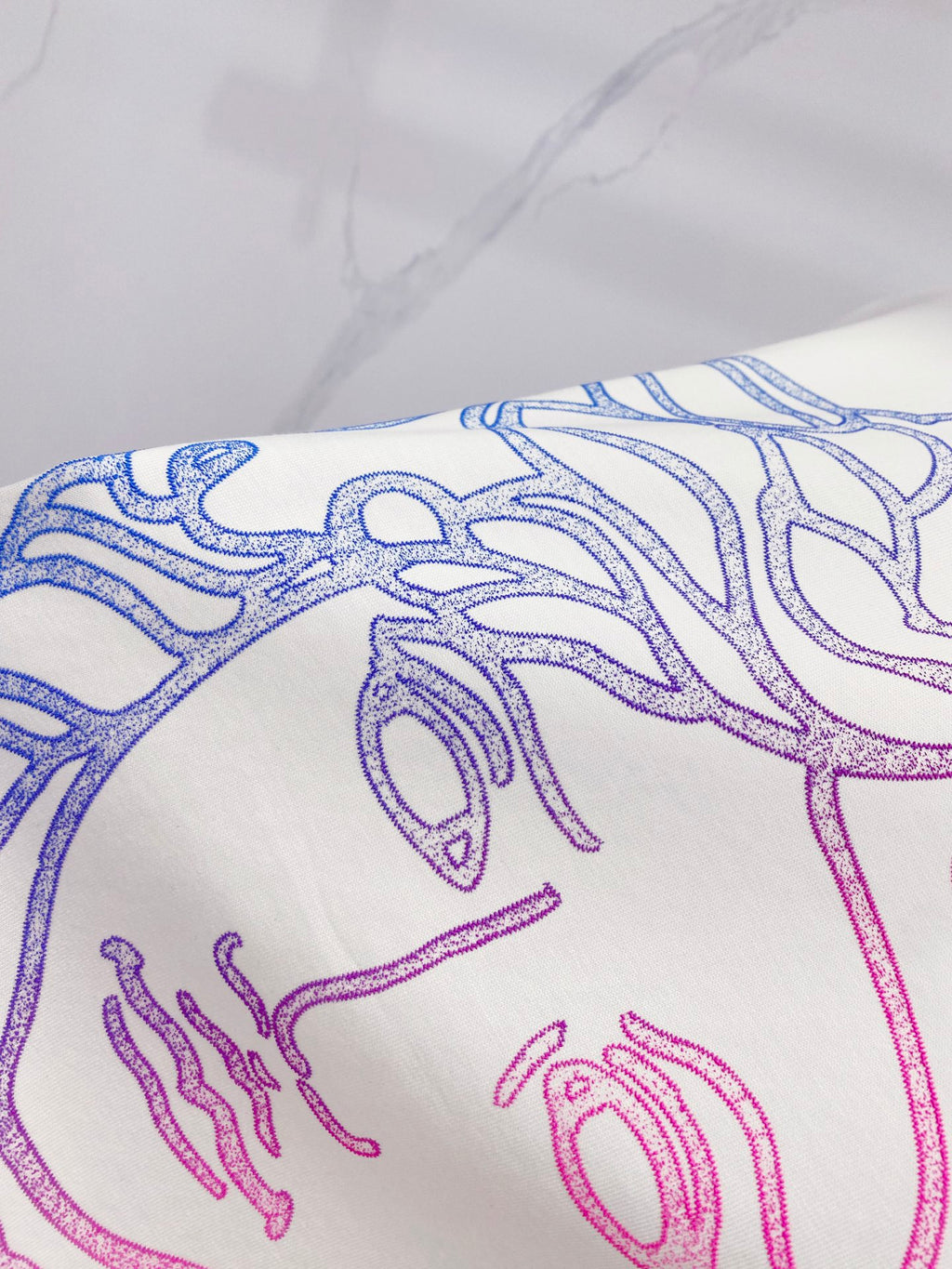 White T-shirt close-up of blue and pink Medusa line graphic