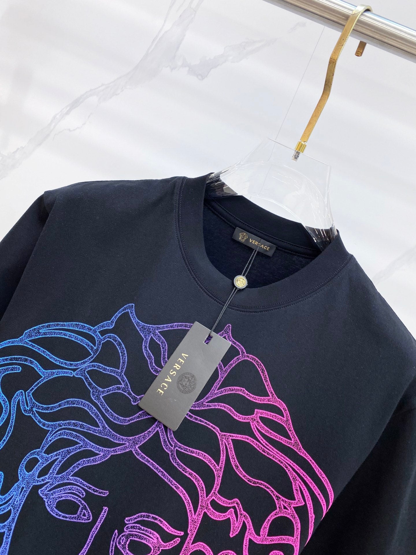 Versace T-shirt with chest graphic and attached hang tag at the collar