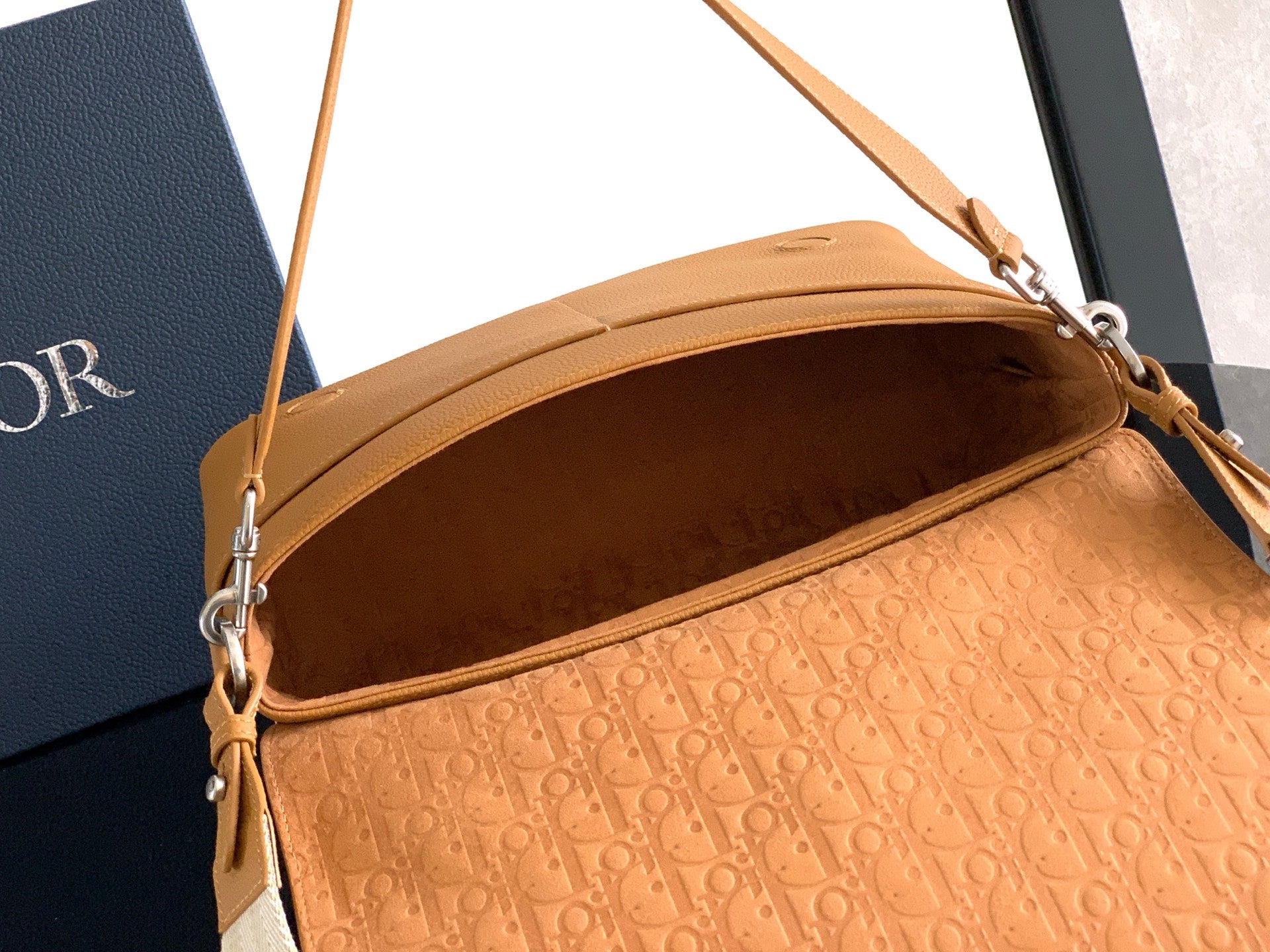 Tan leather shoulder bag open at top, showing patterned fabric lining