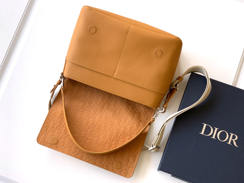 Tan leather mini bag with top flap, drawstring pull and crossbody strap
