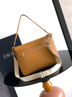 Tan leather shoulder bag with flap and zip pocket front, white strap detail