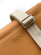 Close-up of tan leather belt strap with Dior logo buckle