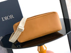 Tan leather clutch-style bag with white webbing strap and flap closure