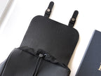 Dior backpack top section with textured leather, drawstring closure, and black webbing straps.