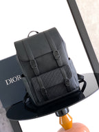 Dior backpack with flap and buckles, textured dark leather, top handle and shoulder straps.