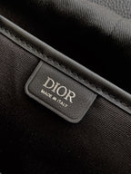 Dior bag interior label tag with printed DIOR text, sewn to dark fabric lining.